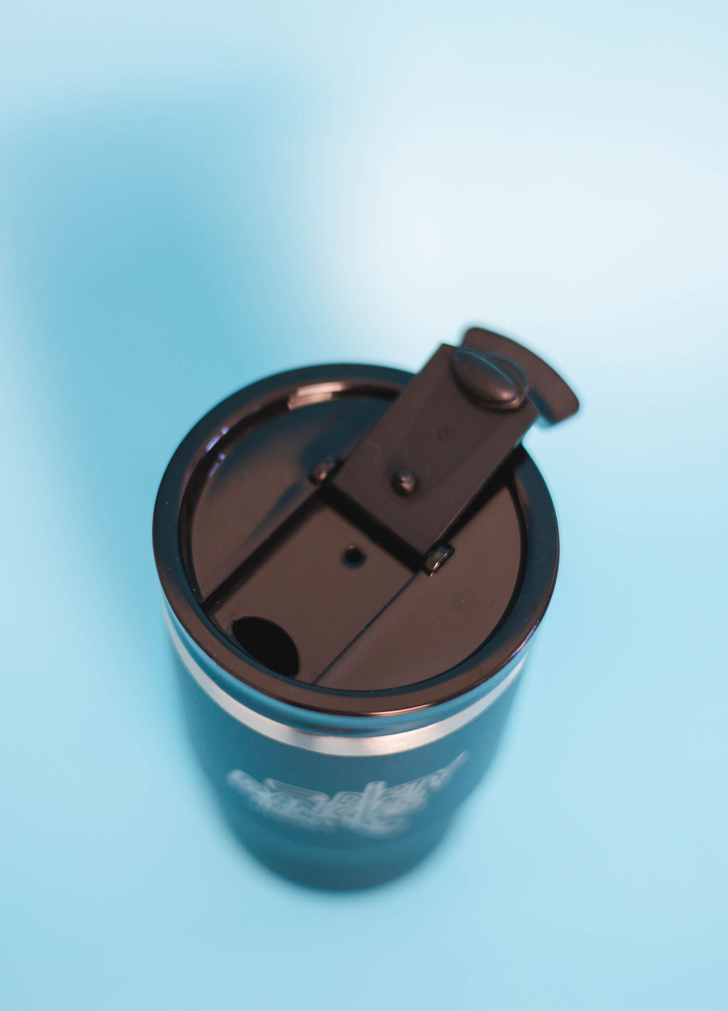 A top down view of a black dirty dangles hockey 12 oz 4 in 1 tumbler drink cooler combo showing the standard tumbler lid