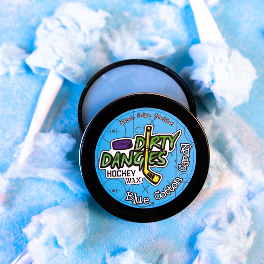 A tin of Dirty Dangles Hockey Stick Wax Blue Cotton Candy Scent sits open on a blue background surrounded by blue cotton candy.