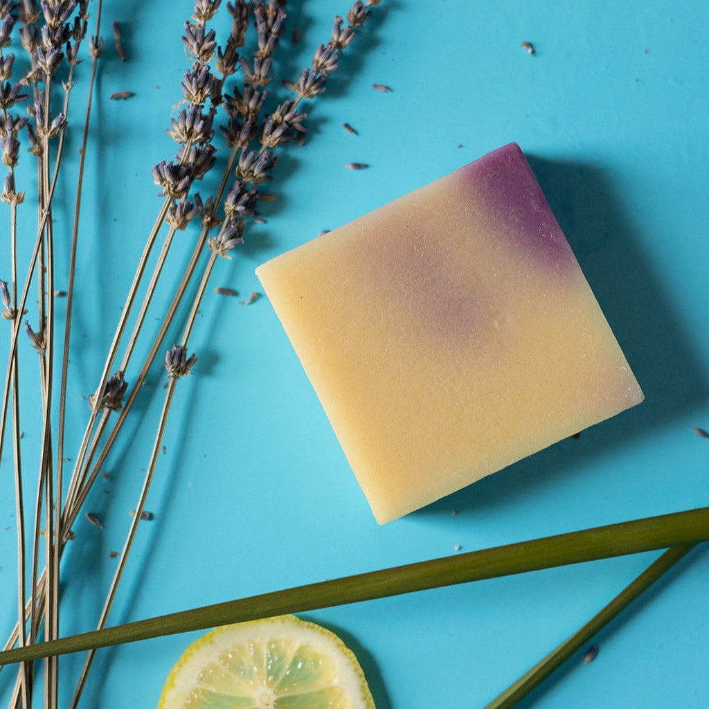 A bar of dirty dangles hockey soap lavender lemongrass scent on a blue background with lavender.