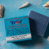 A Blue bar of dirty dangles hockey soap The Michigan scent on a blue background with a blue box with sand and shells