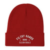 A red dirty dangles knit hockey beanie on a white background. Filthy Hands Clean Goals