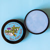 A tin of Dirty Dangles Hockey Stick Wax Blue Cotton Candy Scent sits open on a blue background.