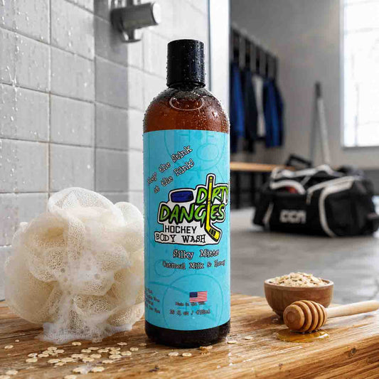 Bottle of Dirty Dancer's Hockey Body Wash on a wooden surface with a shower and towel rack in the background.