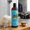 Bottle of Dirty Dancer's Hockey Body Wash on a wooden surface with a shower and towel rack in the background.