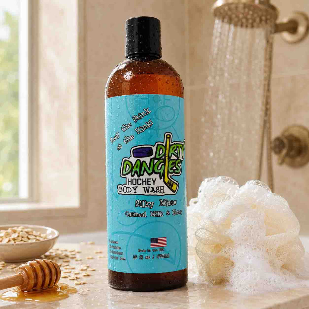 Bottle of Dirty Dancer body wash with honey and a sponge on a bathroom counter.