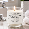 A white scented hockey candle in a bathroom with white towels. Trying to cover up hockey funk