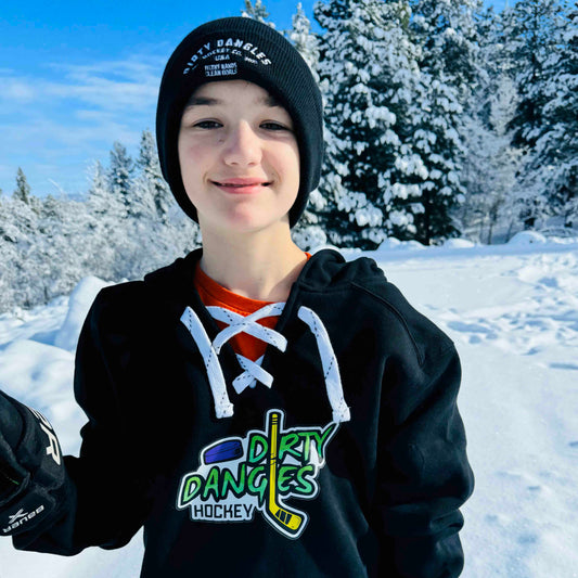A youth hockey player wearing a dirty dangles hockey heavyweight lace up hoodie in the snow