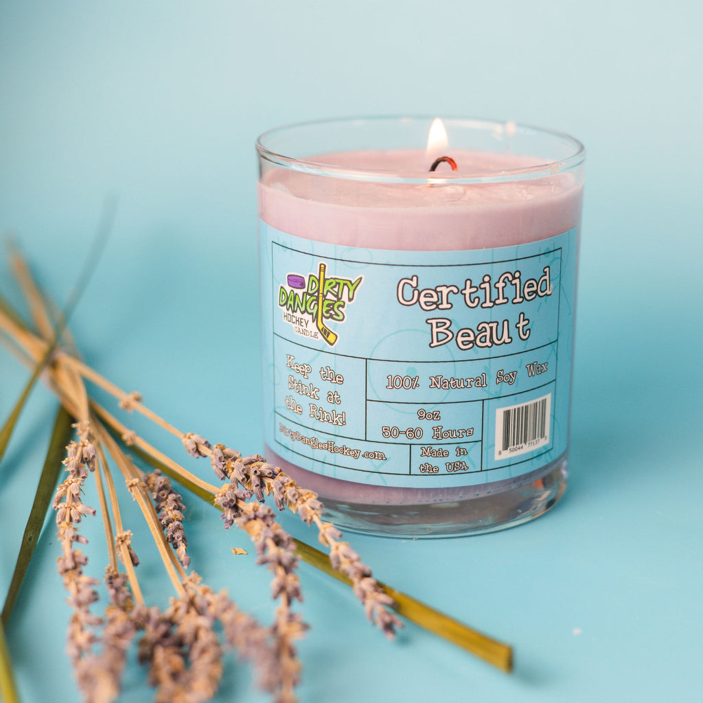 A purple dirty dangles girls and womens hockey candle certified beaut lavender lemongrass scent on a blue background with lavender  and lemongrass