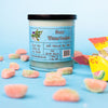 A green dirty dangles natural hockey candle sour watermelon scent on a blue background with sour watermelon candies