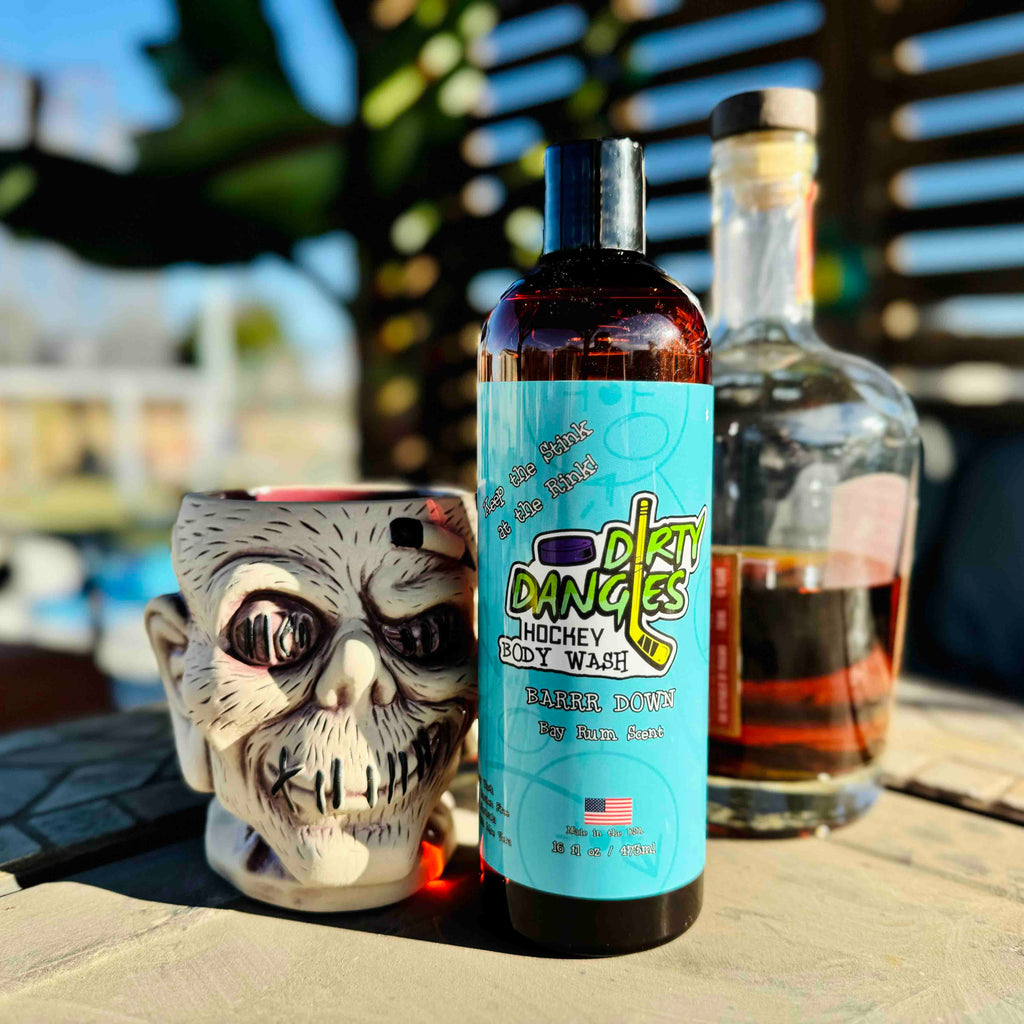 A bottle of dirty dangles hockey body wash Barrr Down scent with a bottle and zombie drink mug