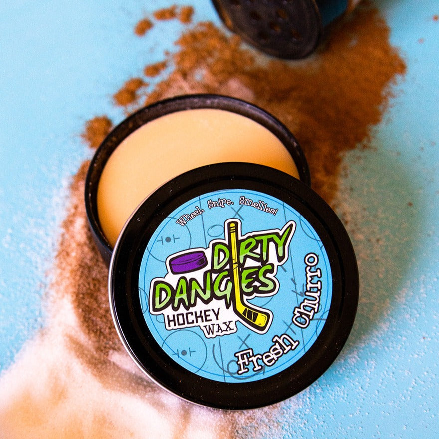 Fresh Churro Scented hockey stick wax  on a blue background surrounded by cinnamon and sugar