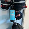 A bottle of stank fighter hockey gear deodorizer hanging from an utty portable hockey gear drying rack