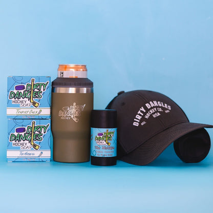 2 bars of hockey soap, a tactical green 2 in 1 drink tumbler can holder, a stick of dirty dangles natural deodorant and a dirty dangles hockey co. hat on a blue background.