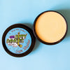 A tin of Dirty Dangles Hockey Stick  Wax Lava Monster Scent sits open on a blue background showing an orange stick wax.