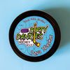 A tin of Dirty Dangles Hockey Stick Wax Lava Monster Scent sits on a blue background.