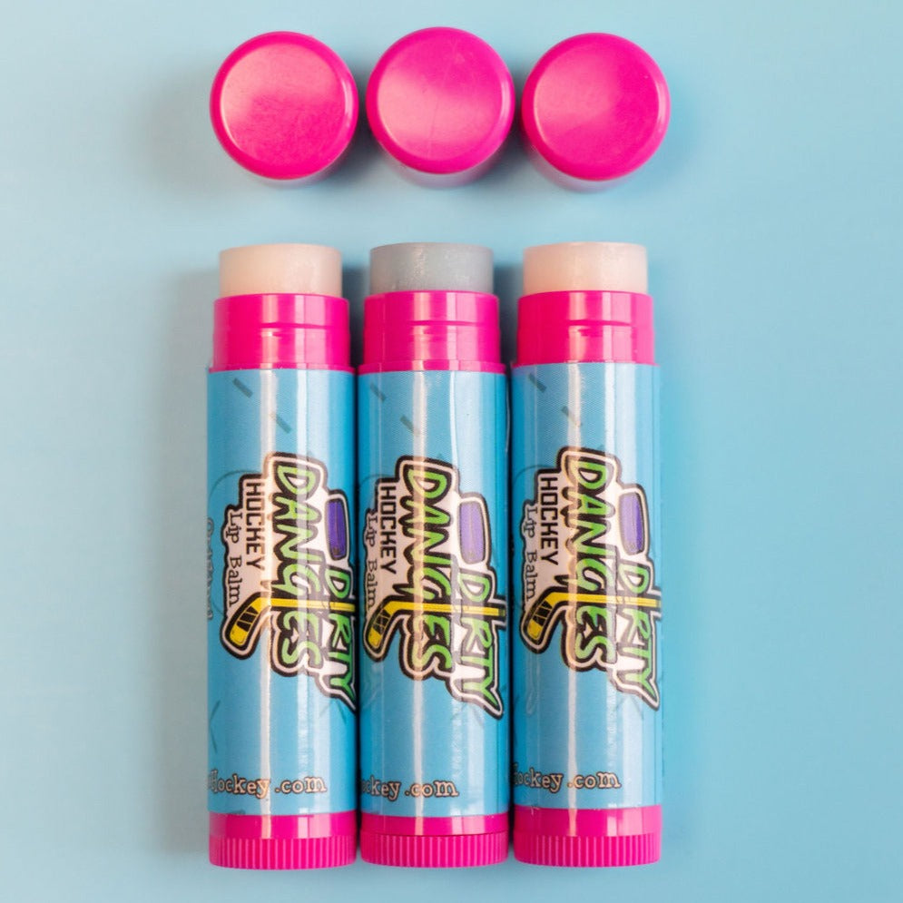 3 pink and blue sticks of lip balm on a blue background. Dirty Dangles hockey lip balm