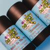 3 tubes of dirty dangles natural handmade deodorant on a blue background. 2 games on the beach, unscented, the michigan.