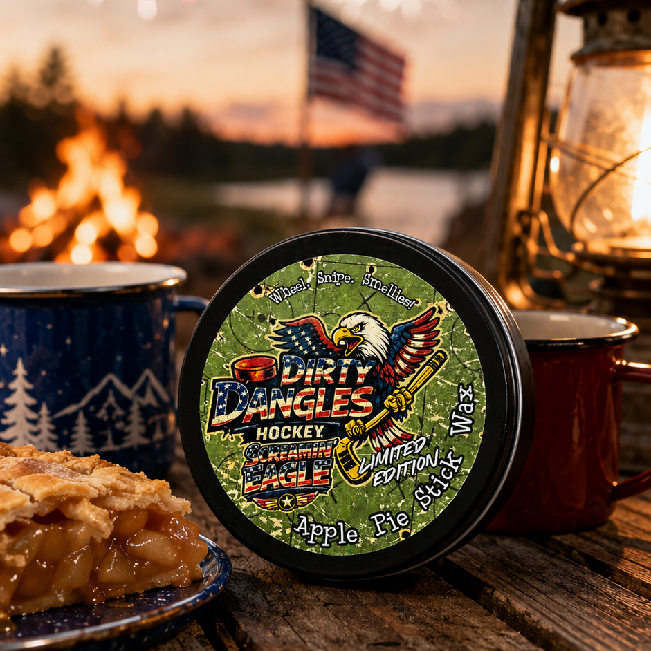 A tin of dirty dangles screamin eagle 4th of july stick wax on a picnic table with apple pie and american flags