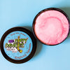 A tin of Dirty Dangles Hockey Stick Wax Strawberry Lemonade Scent sits open on a blue background showing a pink stick wax.