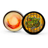 An open tin of dirty dangles tiki deke limited edition tropical stick wax on a white background