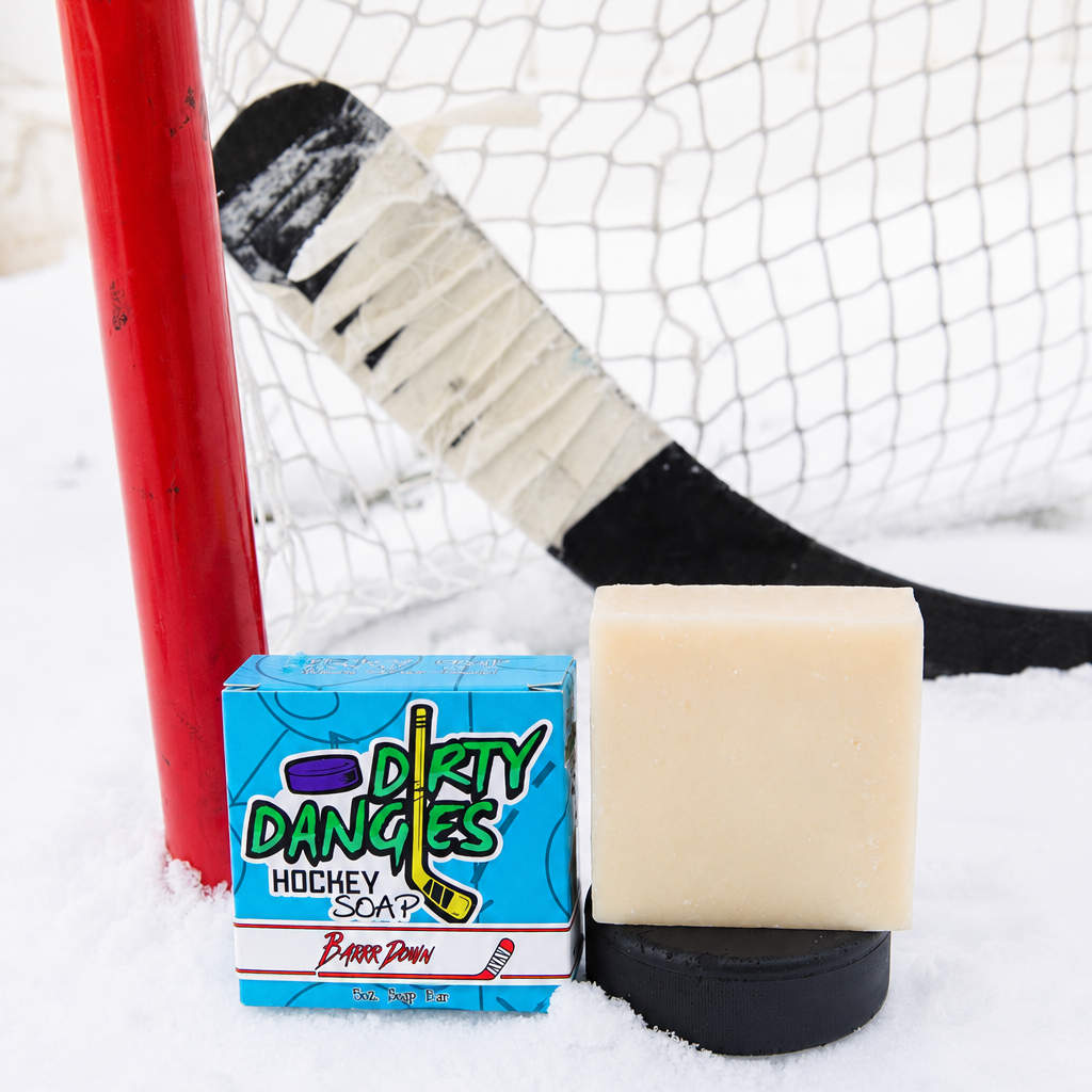 Barrr down bay rum scented hockey soap bar on a snowy background with a hockey stick and hockey net.