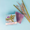 certified beaut lavender lemongrass girl's soap bar on a blue background with lavender flowers and lemongrass sticks