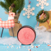 A tin of dirty dangles reindeer farts holiday hockey stick wax on a blue background with candy canes and a stuffed reindeer