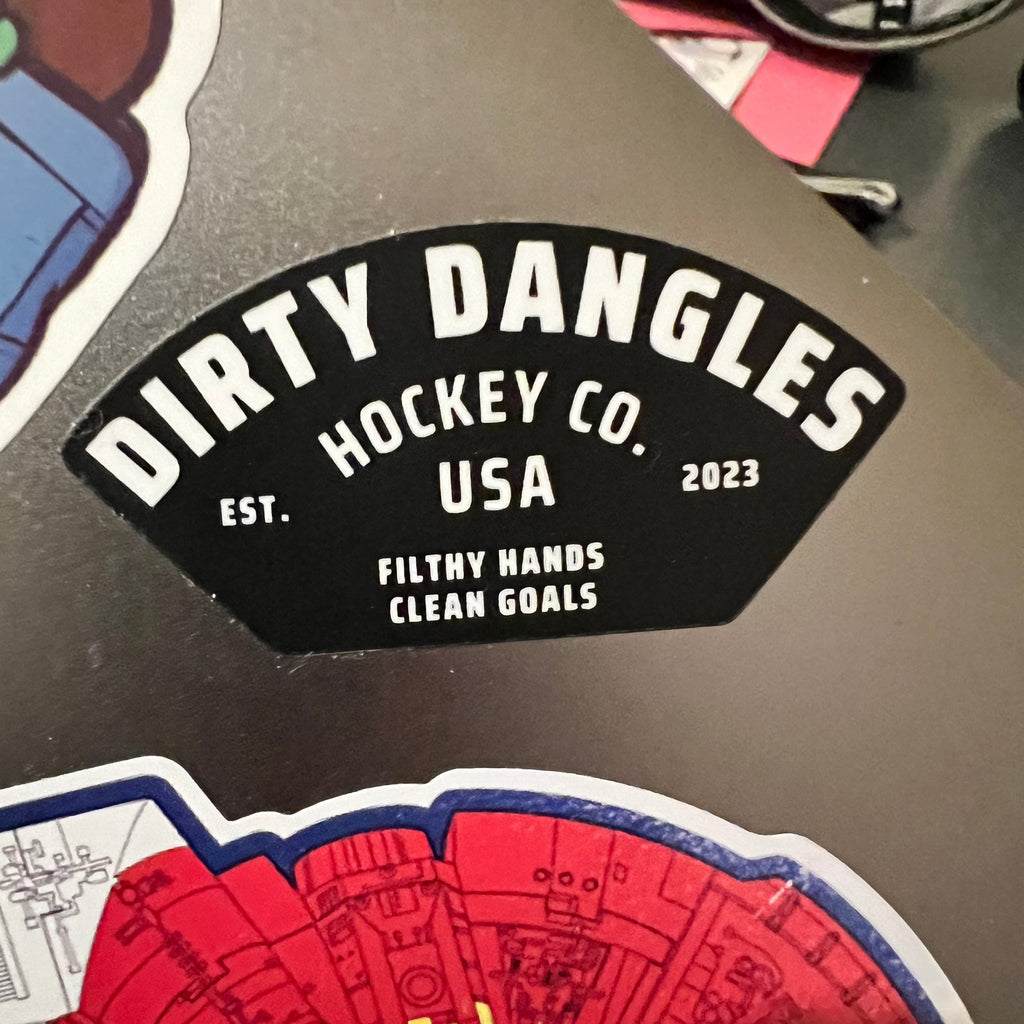 A black dirty dangles hockey co sticker on a laptop