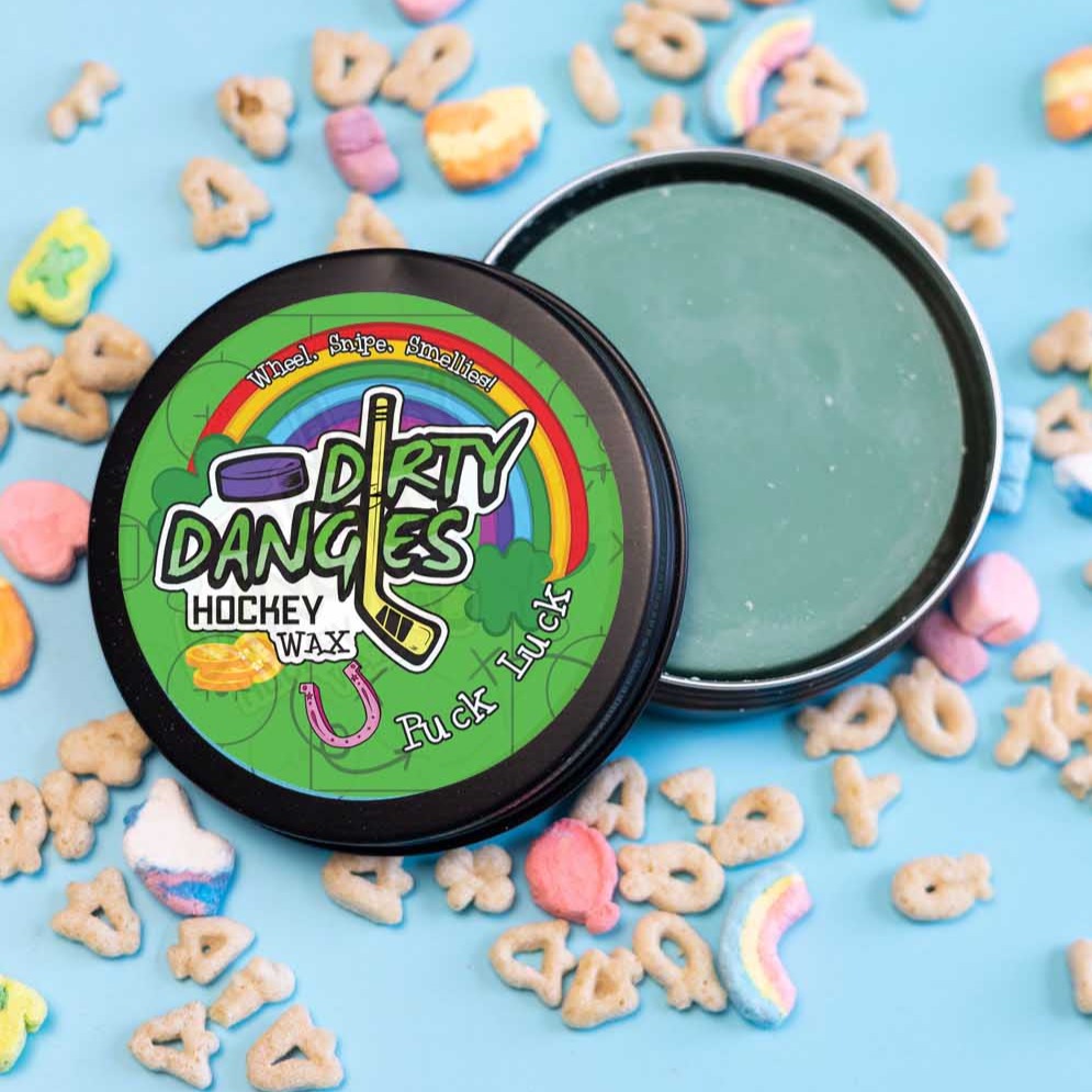 A tin of Dirty Dangles Hockey Wax Puck Luck St Patrick's Day scent on a blue background with lucky breakfast cereal