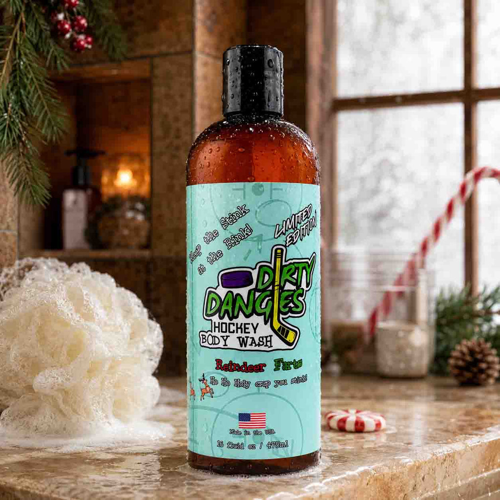 A bottle of Dirty Dangles Hockey Body Wash reindeer farts candy cane scent on a bathroom counter with holiday decorations in the background.