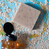 a brown silky mitts oatmeal milk and honey hockey soap bar on a blue background with honey and oats