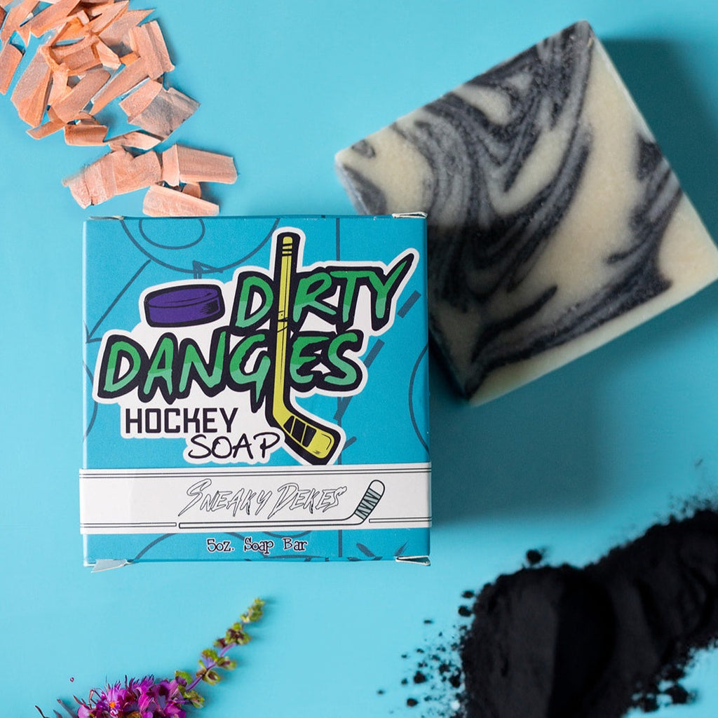 sneaky dekes black and white swirl hockey soap bar and box on a blue background with sandalwood and charcoal