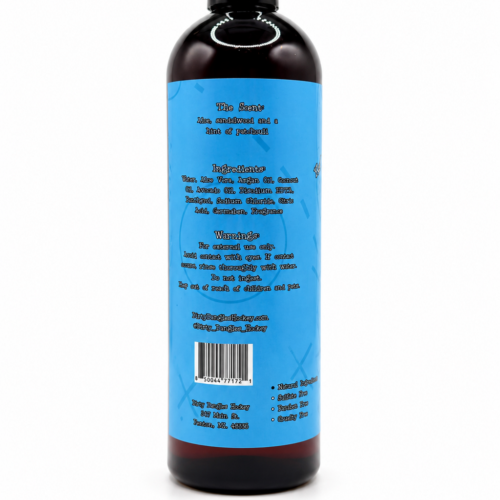 A dark amber bottle with a black cap, showing the back label of dirty dangles sneaky dekes scented body wash. The label is bright blue with black text, and the bottle is photographed on a clean white background.