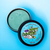 A tin of dirty dangles sour watermelon hockey stick wax on a blue background