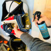 A woman spraying a hockey glove with stank fighter deodorizing hockey spray