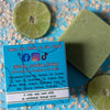 the back of a tendies only green jasmine lime hockey goalie soap on a blue background with limes, jasmine flowers and oatmeal