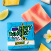a bar of tiki deke tropical coconut girls hockey soap on a blue background with coconut, pineapple, limes and flowers