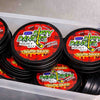 Multiple containers of Dirty Dangles Waffle Sauce scented hockey wax with red and black labels.