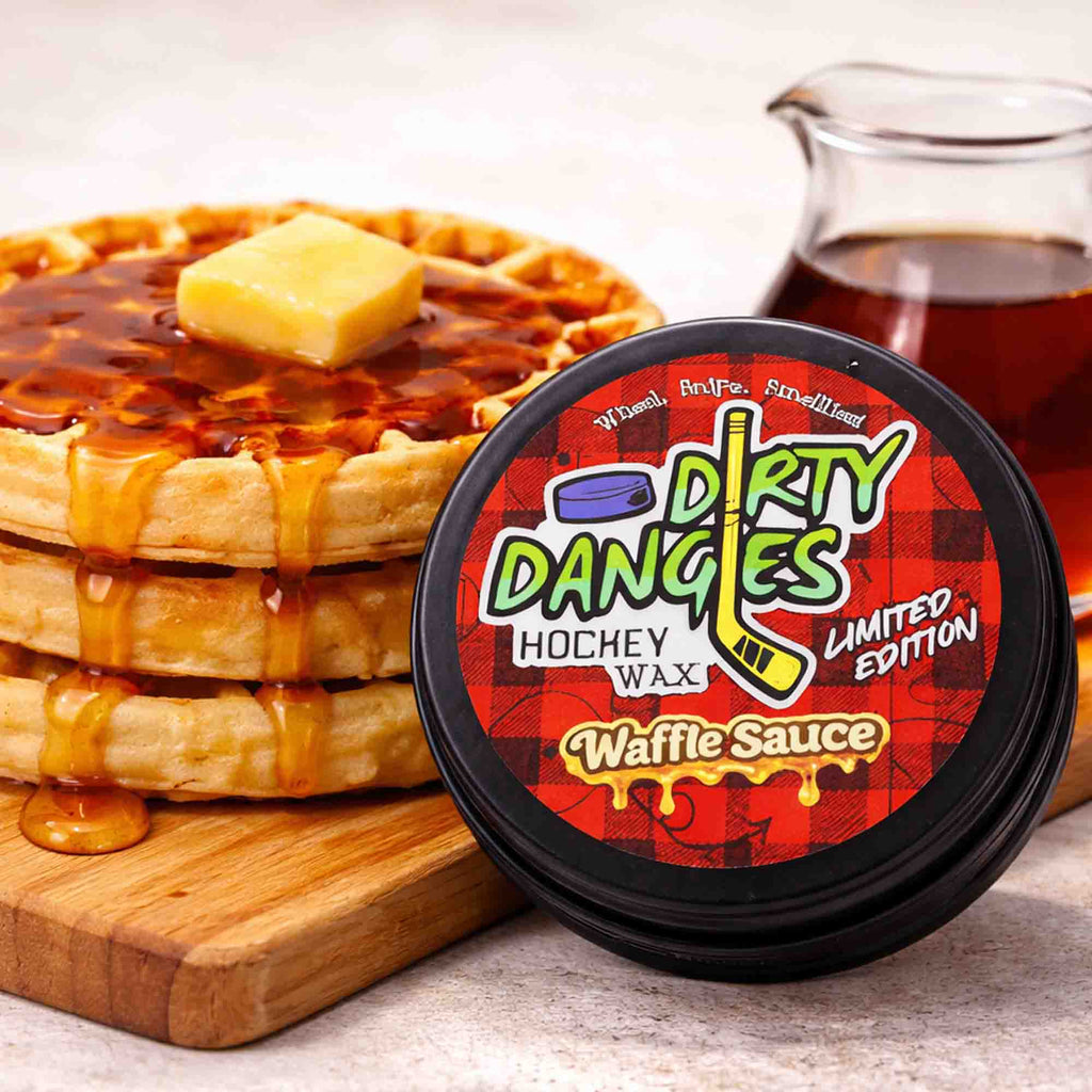 Container of 'Dirty Dangles' hockey wax Waffle Sauce Scent with a stack of waffles and syrup on a wooden board.