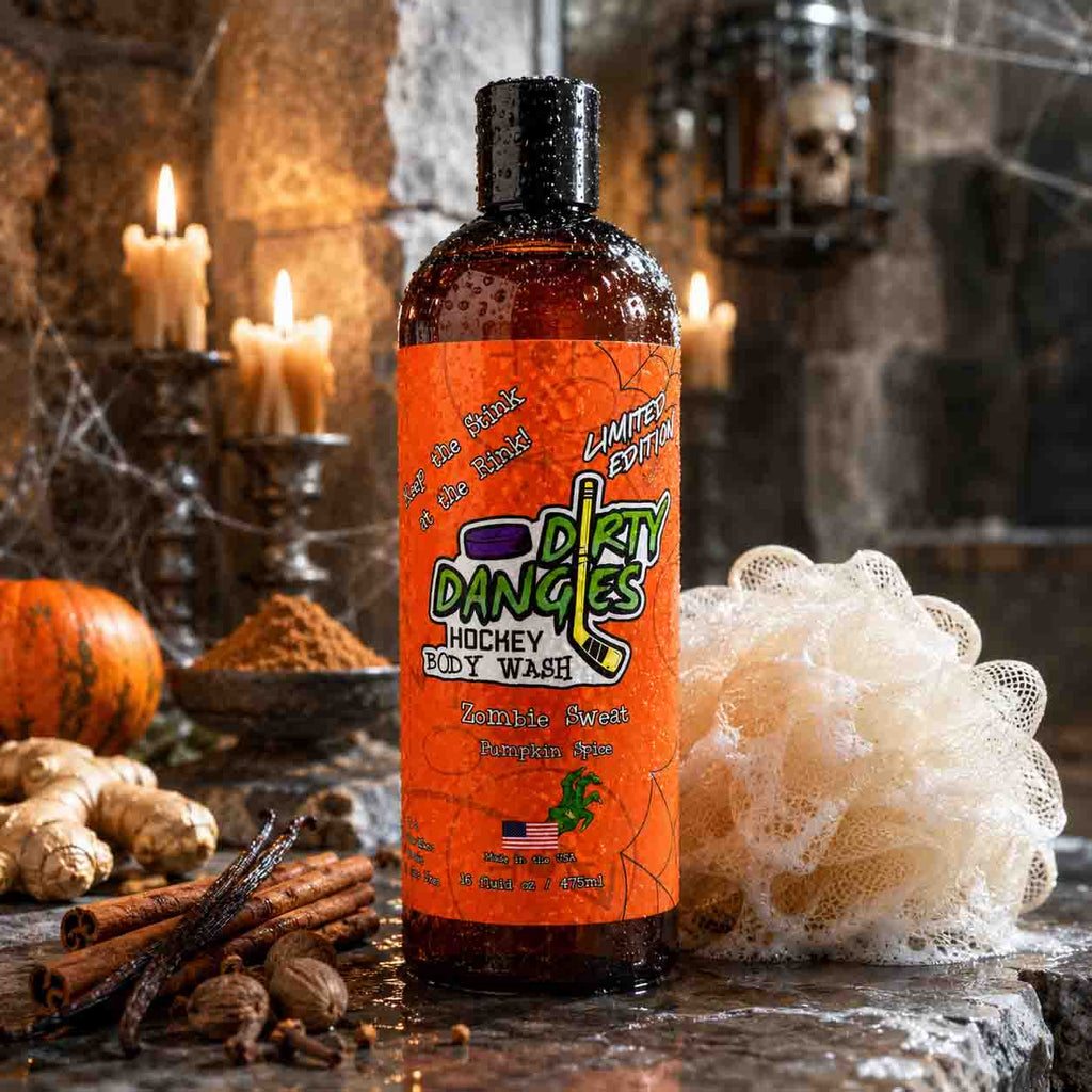 A bottle of Dirty Dangles Hockey body Wash in Limited Edition Zombie Sweat Pumpkin Spice scent in a spooky Halloween shower with candles, a loofah, ginger, and spices.
