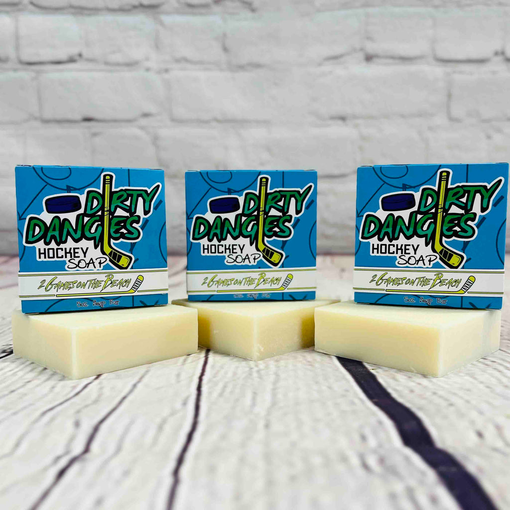 3 bars of dirty dangles 2 games on the beach scent soap against a wood and brick background. Dirty Dangles hockey soap.