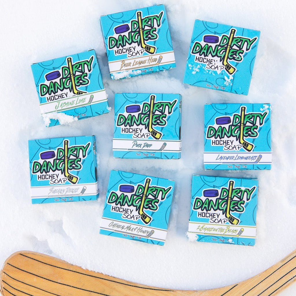 8 boxes of dirty dangles hockey soap on a snowy background with a hockey stick.