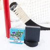 A black soap bar sits in the snow with a hockey goal, hockey puck and a hockey stick. Puck Drop