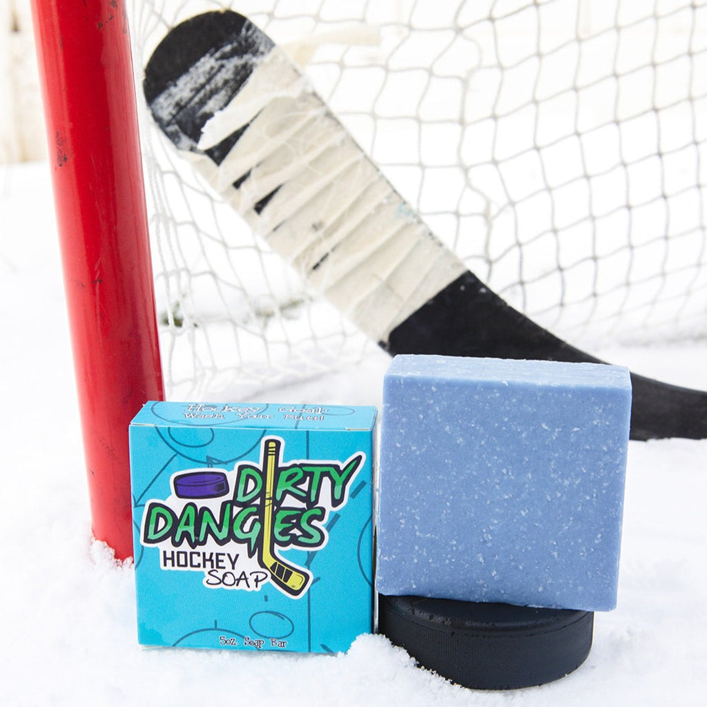 A blue soap bar sits in the snow with a hockey goal, hockey puck and a hockey stick. The Michigan